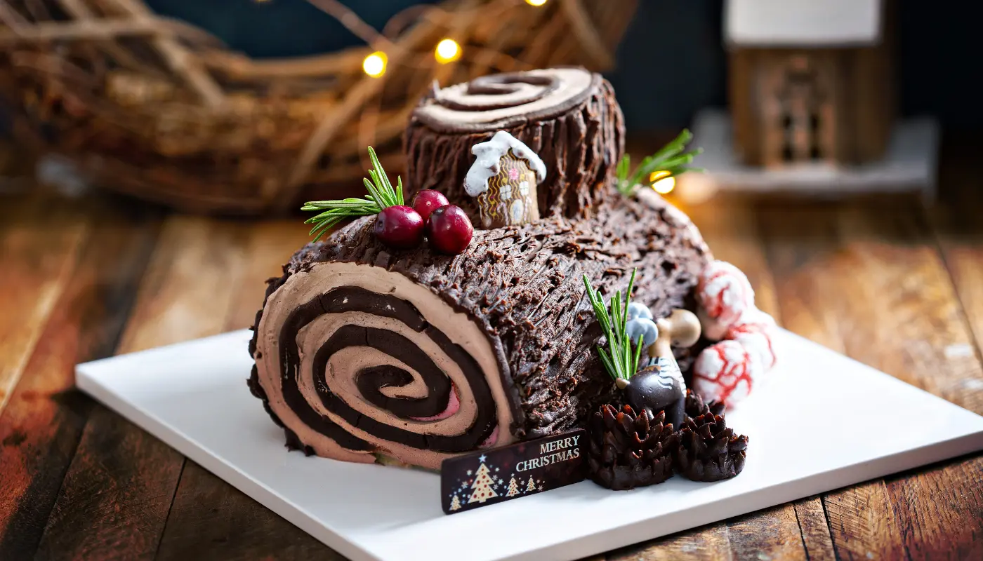 Chocolate Buche de Noel or Yule log on a Christmas table