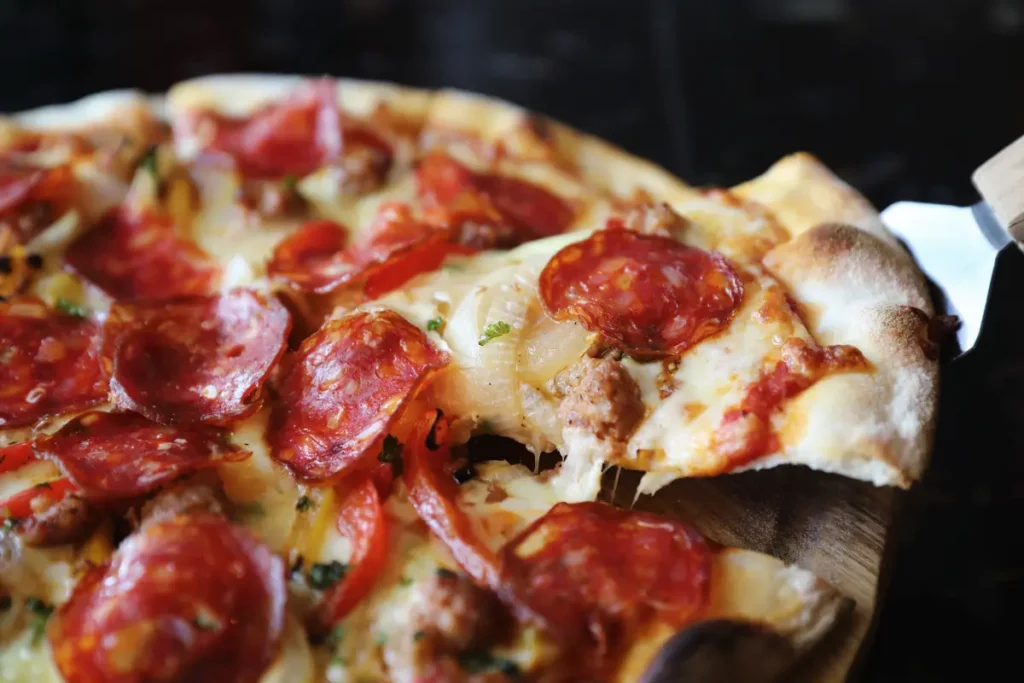 A meat lovers pizza with pepperoni, sausage meat, red peppers and cheese