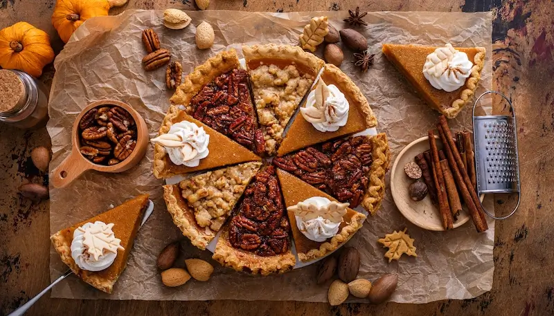 Thanksgiving desserts with a mix of pumpkin pie, pecan pie and other desserts.