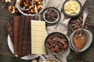 White, milk and dark chocolate tablets along with some nuts, chocolate-coated almonds and other types of chocolates