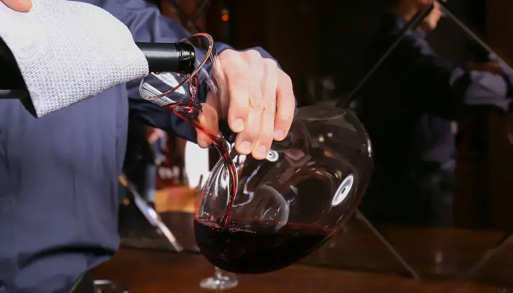 A red wine being poured into a decanter