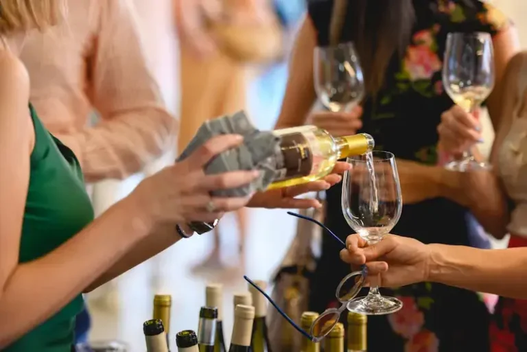 A woman pouring wine into glasses at a tasting