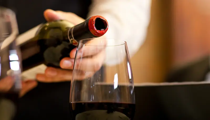 Someone pouring a red wine in a glass