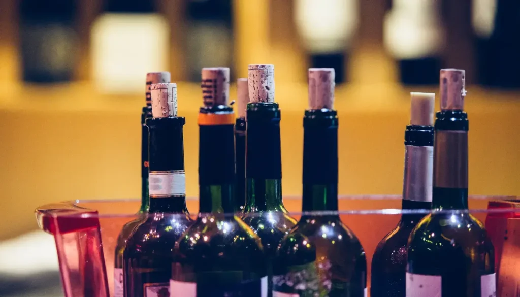 Opened wine bottles with their corks pushed back in, chilling in an ice bucket