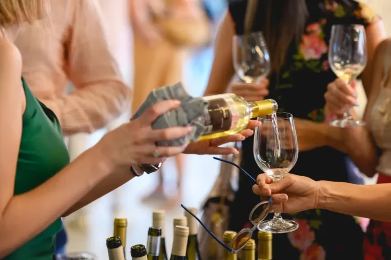 A woman pouring wine into glasses at a tasting