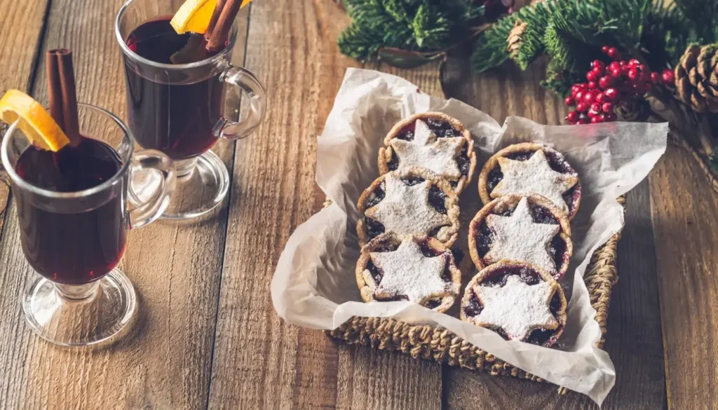A mug of mulled wine served with mince pies